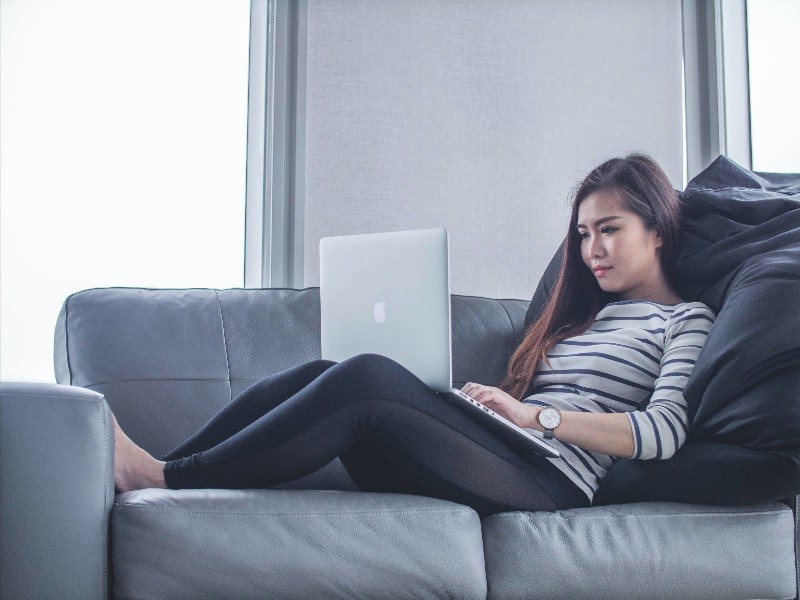 Woman on laptop on couch