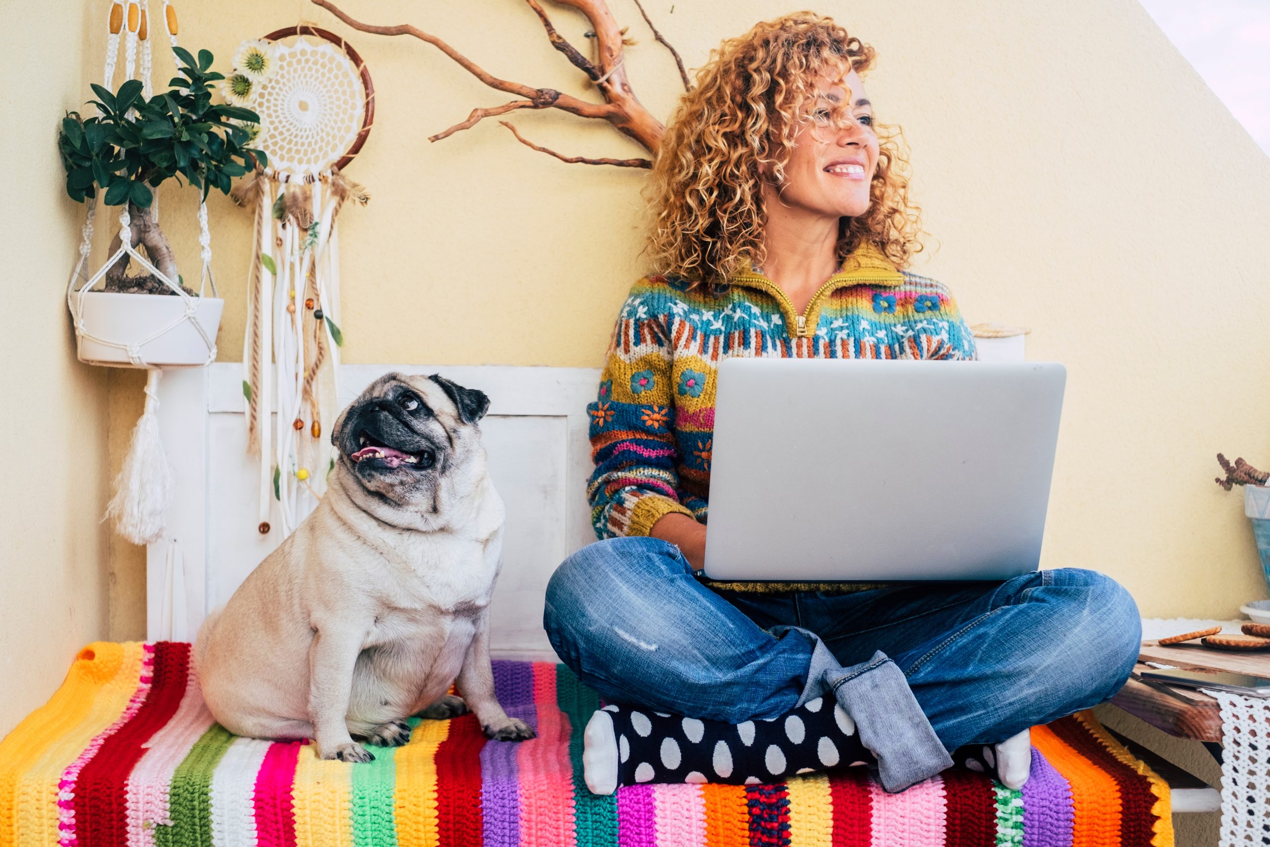 Woman on computer on bed with dog