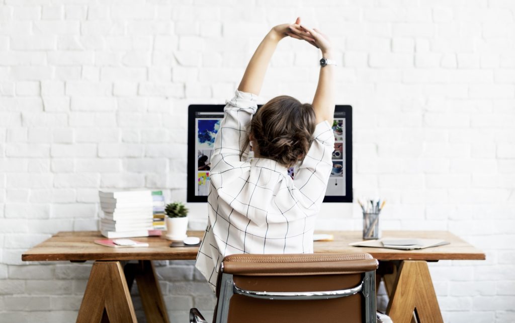 Person sitting at home stretch looking at computer