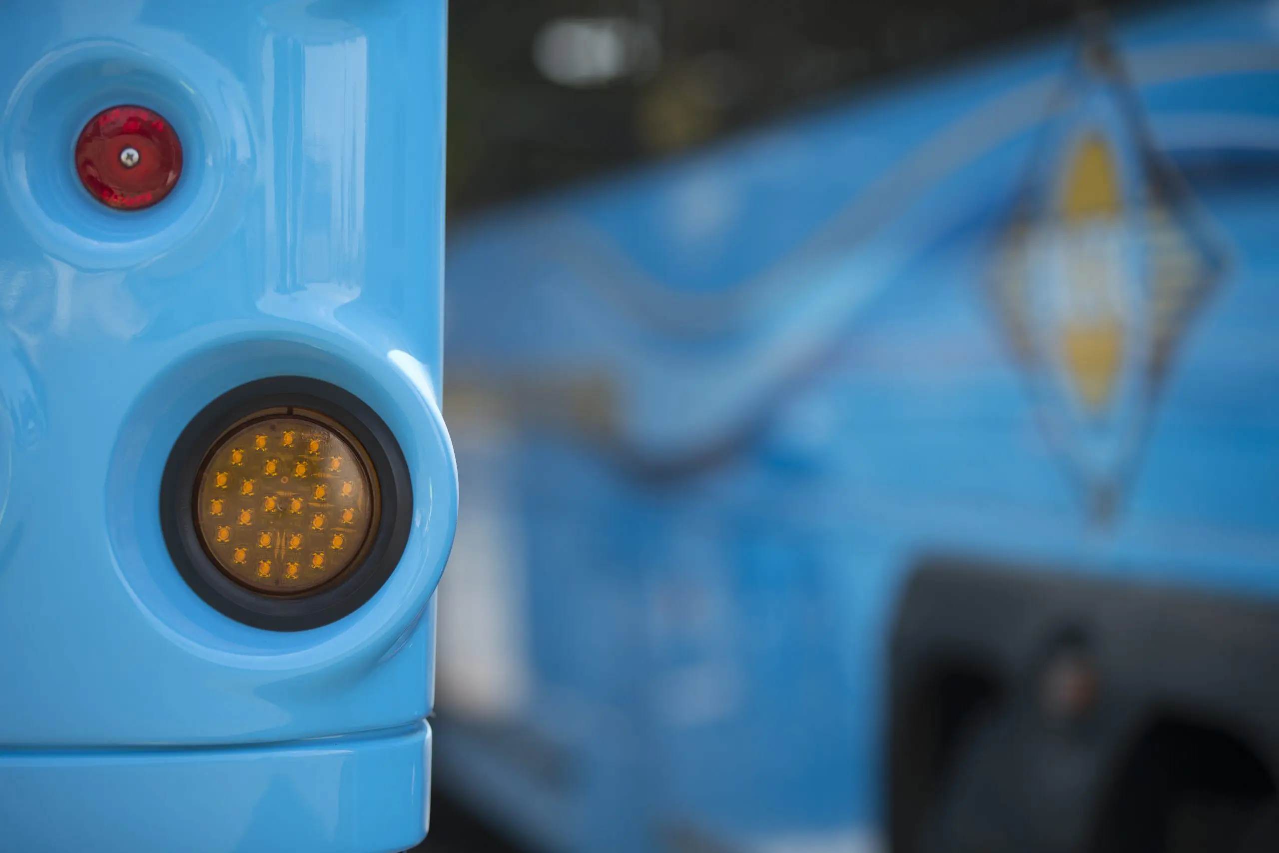 Blue bus with illuminated yellow warning light at Goventura Staging facility.