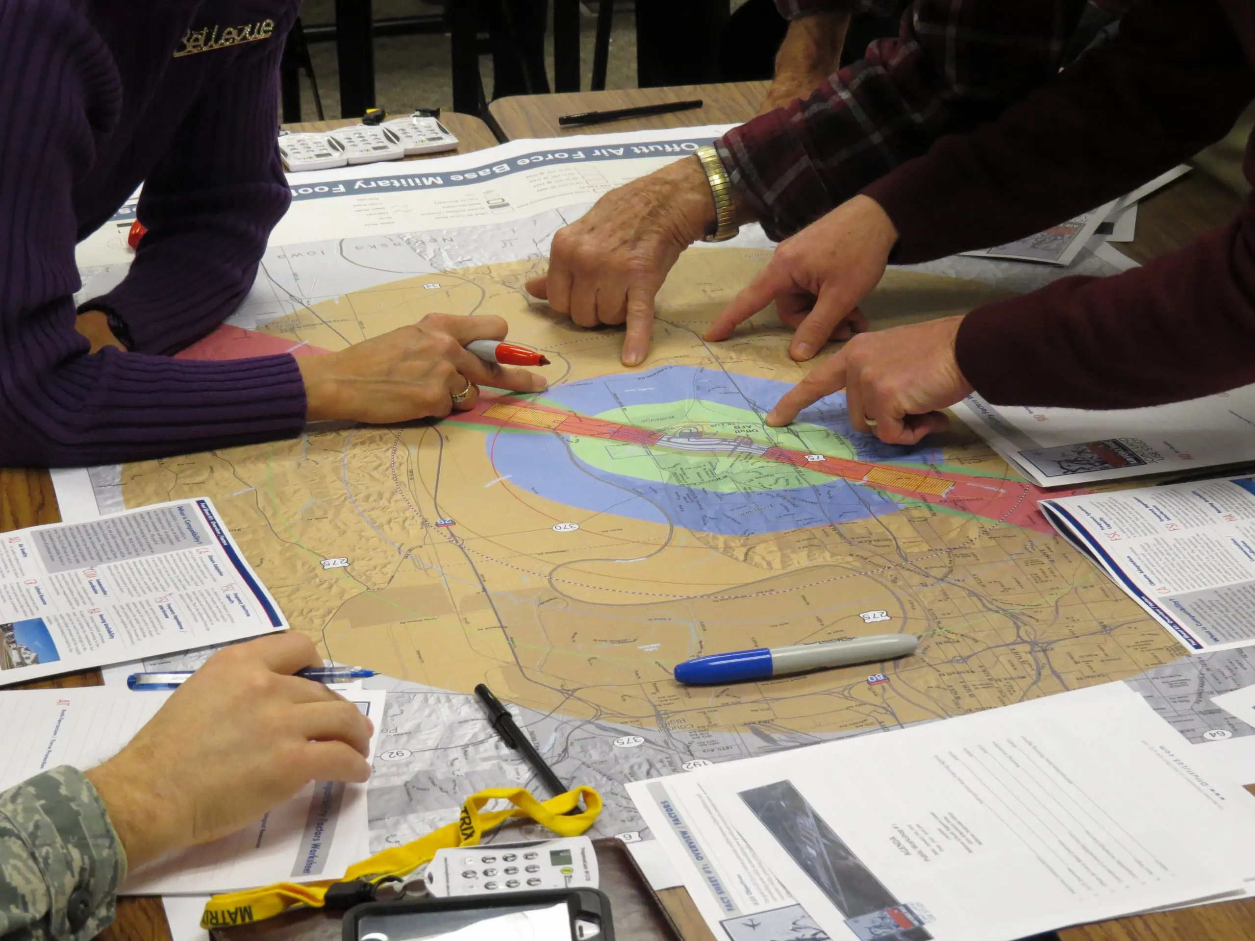 Persons hand on drafting table with a map and other tools