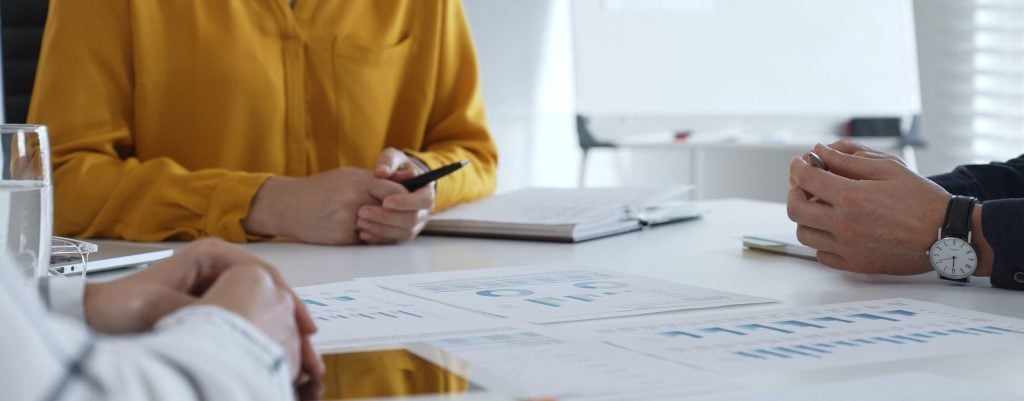 Peoples hands on a desk in a meeting