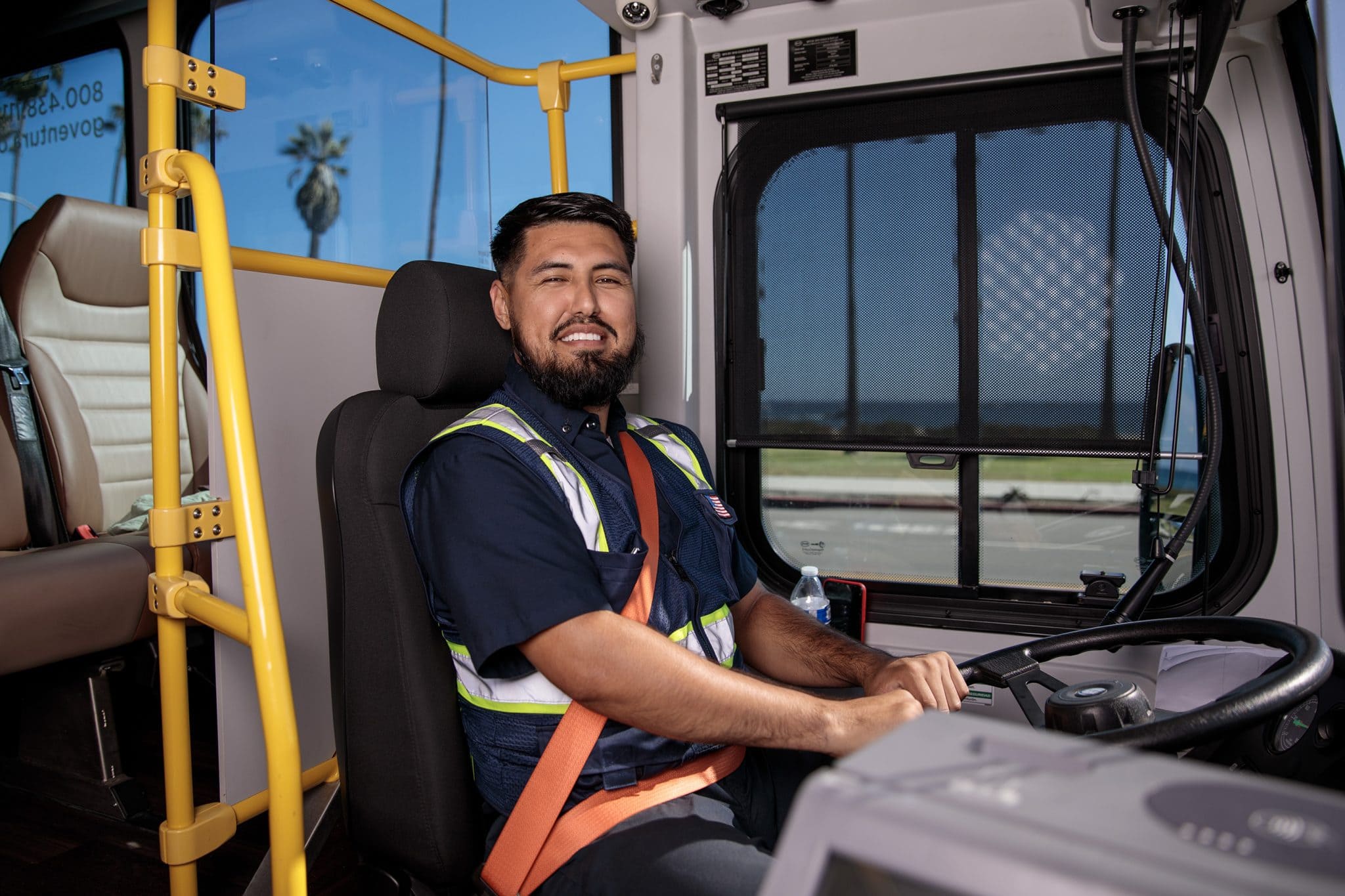 Image of a bus driver at the wheal of his bus smiling