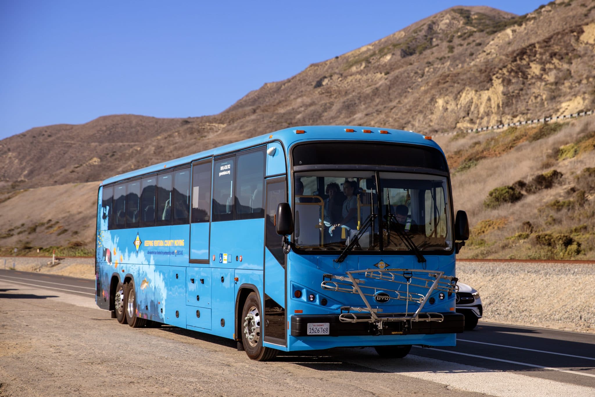 Blue bus on scenic mountain road at Goventura Staging.