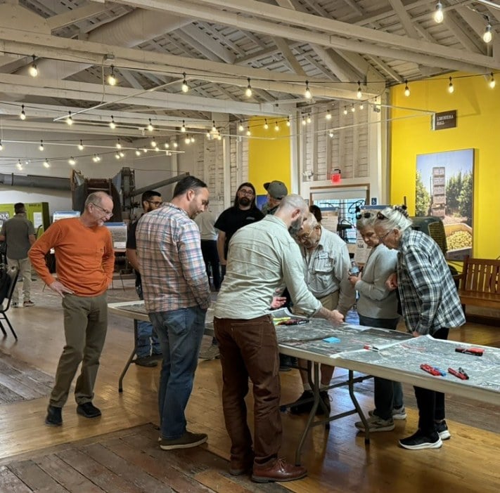 Community members and VCTC staff gathered around a Santa Paula Branch Line corridor map at a project outreach meeting.